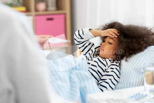 Image of doctor measuring sick girl's temperature