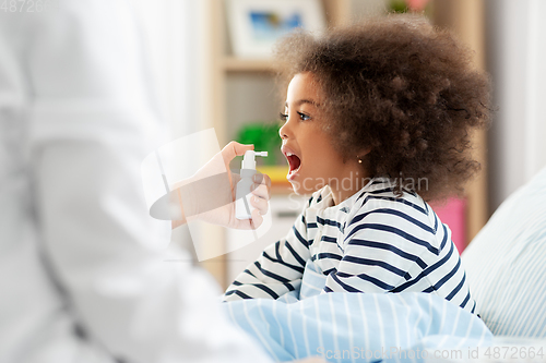 Image of doctor with medicine treats sick girl at home