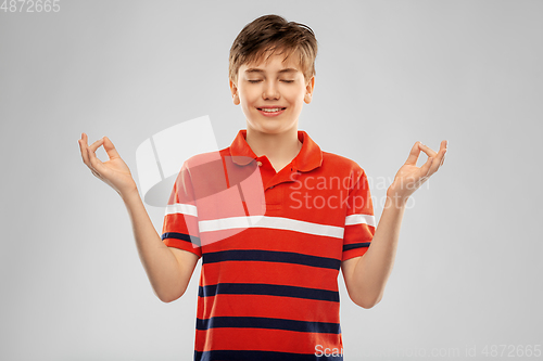 Image of happy smiling meditating boy in red polo t-shirt