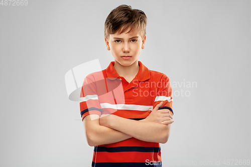 Image of portrait of unhappy boy in red polo t-shirt