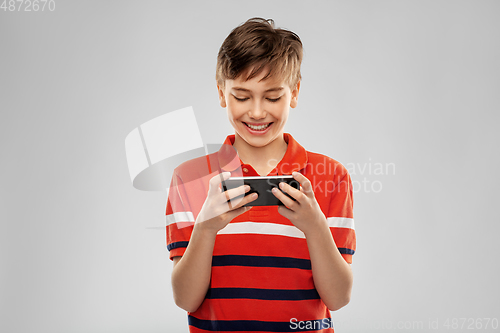 Image of portrait of happy smiling boy with smartphone