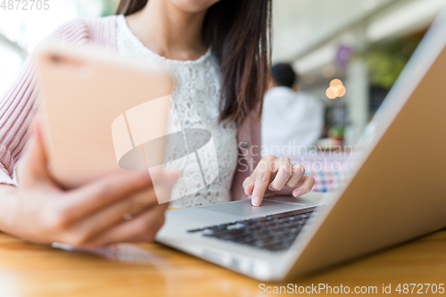 Image of Woman use of cellphone and laptop computer