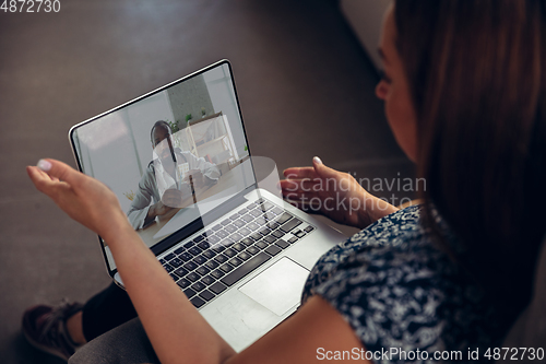 Image of Close up of young woman getting online medical help and advice during videocall with doctor checking symtoms aand explaining the drug\'s reciepes