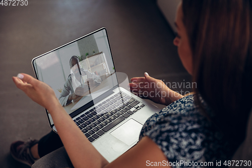 Image of Close up of young woman getting online medical help and advice during videocall with doctor checking symtoms aand explaining the drug\'s reciepes