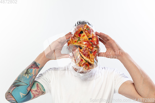 Image of Male face covered with oilcloth, cellophane and unhealthy food, hard to breathe. People lost their faces, can\'t notice the environmental pollution made by themself.