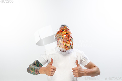 Image of Male face covered with oilcloth, cellophane and unhealthy food, hard to breathe. People lost their faces, can\'t notice the environmental pollution made by themself.