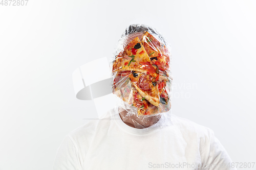 Image of Male face covered with oilcloth, cellophane and unhealthy food, hard to breathe. People lost their faces, can\'t notice the environmental pollution made by themself.