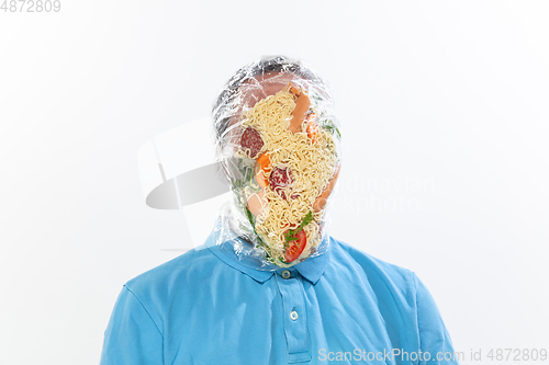 Image of Male face covered with oilcloth, cellophane and unhealthy food, hard to breathe. People lost their faces, can\'t notice the environmental pollution made by themself.