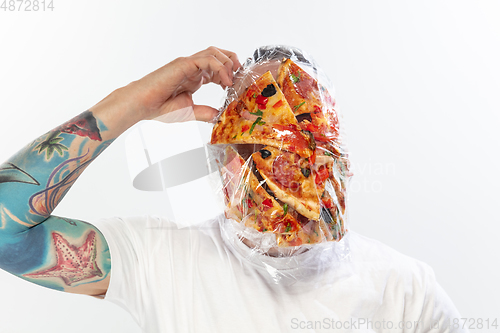 Image of Male face covered with oilcloth, cellophane and unhealthy food, hard to breathe. People lost their faces, can\'t notice the environmental pollution made by themself.