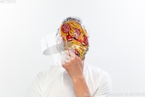 Image of Male face covered with oilcloth, cellophane and unhealthy food, hard to breathe. People lost their faces, can\'t notice the environmental pollution made by themself.