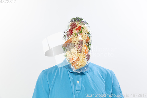 Image of Male face covered with oilcloth, cellophane and unhealthy food, hard to breathe. People lost their faces, can\'t notice the environmental pollution made by themself.