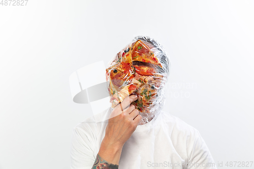 Image of Male face covered with oilcloth, cellophane and unhealthy food, hard to breathe. People lost their faces, can\'t notice the environmental pollution made by themself.