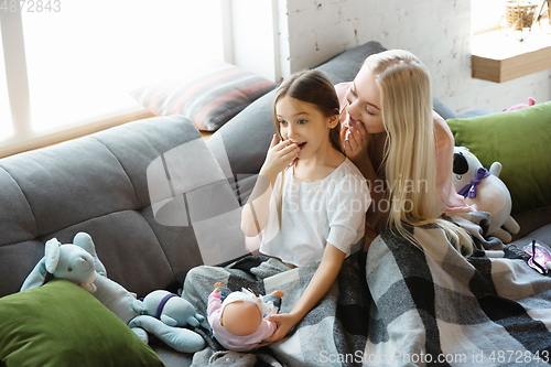 Image of Mother and daughter, sisters have quite, beauty and fun day together at home. Comfort and togetherness. Telling a secrets, joking.