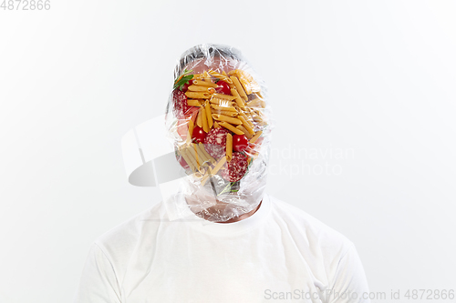 Image of Male face covered with oilcloth, cellophane and unhealthy food, hard to breathe. People lost their faces, can\'t notice the environmental pollution made by themself.