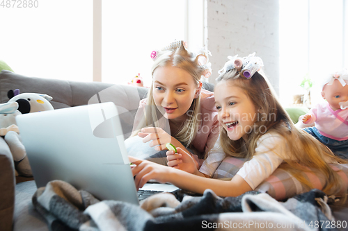 Image of Mother and daughter, sisters have quite, beauty and fun day together at home. Comfort and togetherness. Watching series, eating healthy food, do a hairstyle