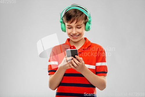 Image of boy in headphones listening to music on smartphone