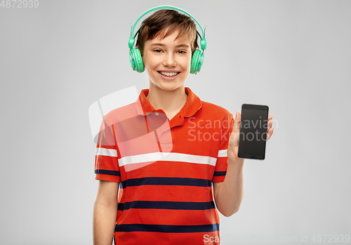 Image of boy in headphones listening to music on smartphone