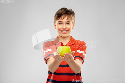 Image of portrait of happy smiling boy holding green apple