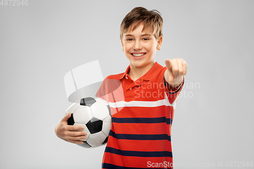 Image of happy boy with soccer ball pointing to camera