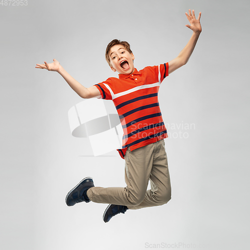 Image of happy smiling young boy jumping in air