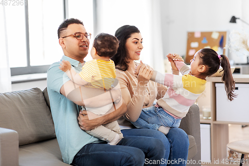 Image of portrait of happy family sitting on sofa at home