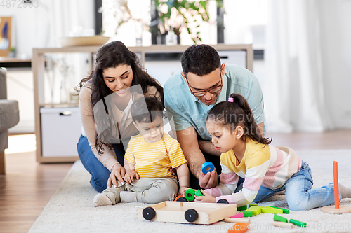 Image of happy family palying with wooden toys at home