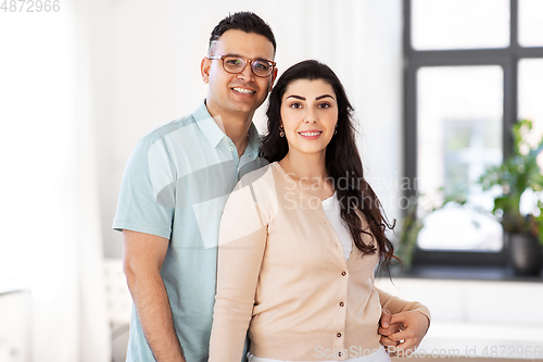 Image of happy couple hugging at home