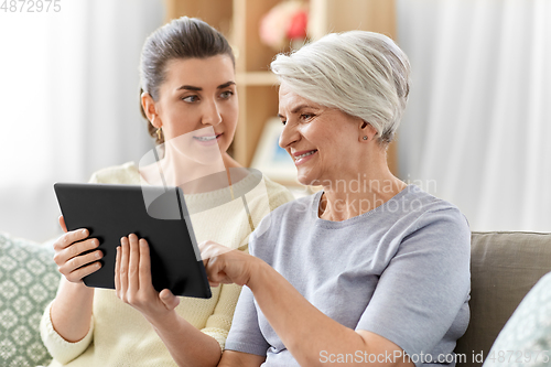 Image of daughter and senior mother with tablet pc at home