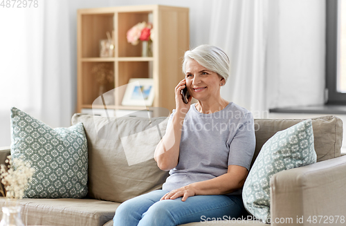 Image of senior woman calling on smartphone at home