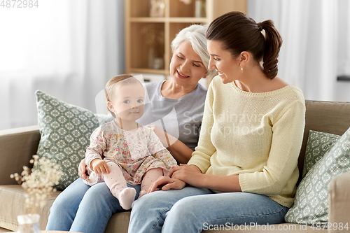 Image of mother, daughter and grandmother on sofa at home