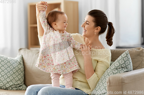 Image of happy mother with little baby daughter at home