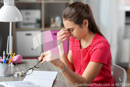 Image of tired teenage student girl with glasses at home