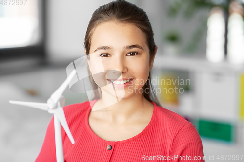 Image of happy teenage girl with toy wind turbine