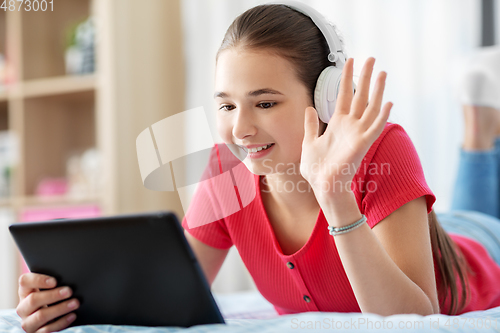 Image of girl having vide call on tablet computer at home