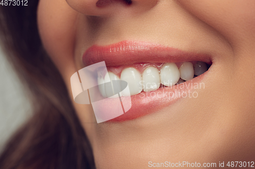 Image of Close up of beautiful female face, lips and teeth with bright stylish make up isolated on grey studio backgroud
