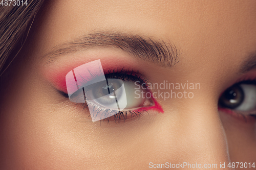 Image of Close up of beautiful female face, eyes with bright stylish make up isolated on grey studio backgroud