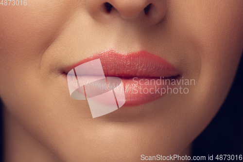 Image of Close up of beautiful female face, lips with bright stylish make up isolated on grey studio backgroud