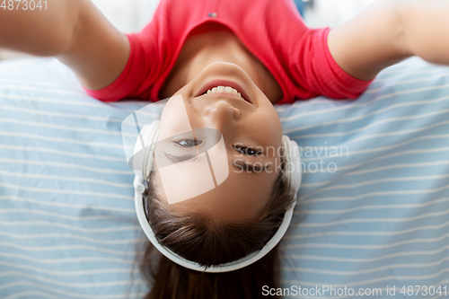 Image of girl in headphones listening to music at home