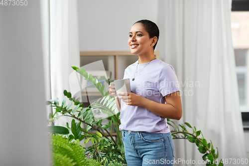 Image of african american woman drinking coffee at home