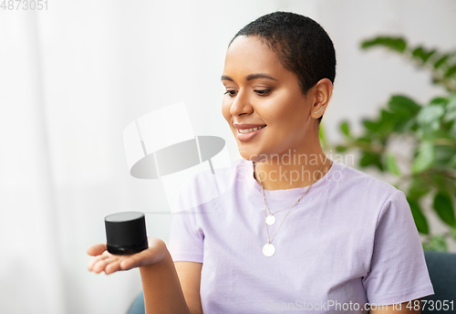 Image of african american woman with smart speaker at home