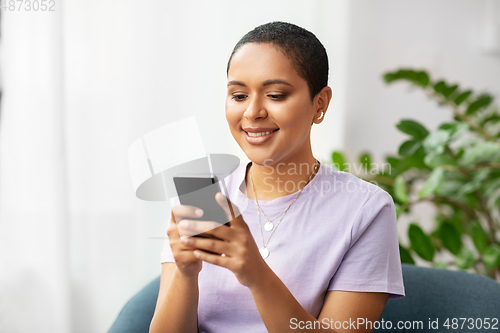 Image of african american woman with smartphone at home