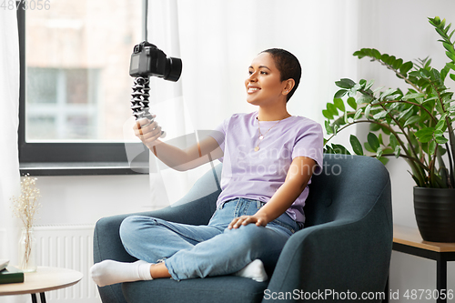 Image of female blogger with camera video blogging at home