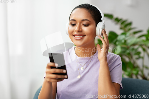 Image of woman with smartphone listening to music at home