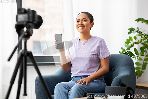 Image of female blogger with camera video blogging at home