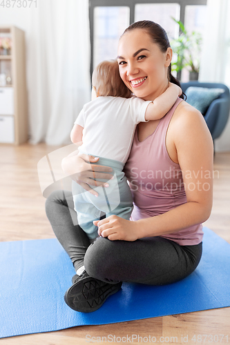 Image of happy mother with little baby at home