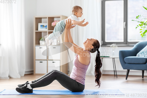Image of happy mother with little baby exercising at home