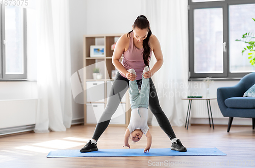 Image of happy mother with little baby exercising at home