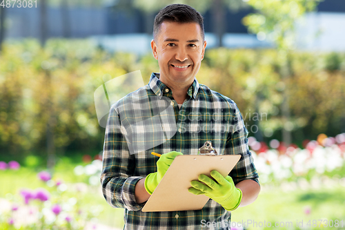 Image of man with clipboard and flowers at summer garden