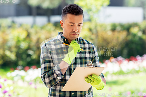 Image of man with clipboard at summer garden