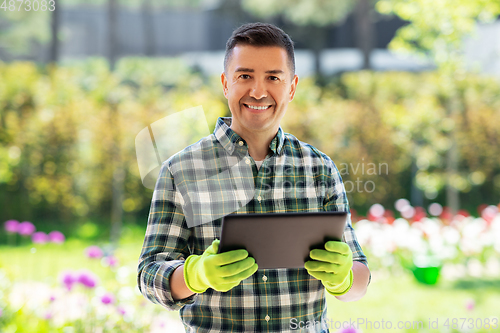 Image of happy man with tablet pc at summer garden